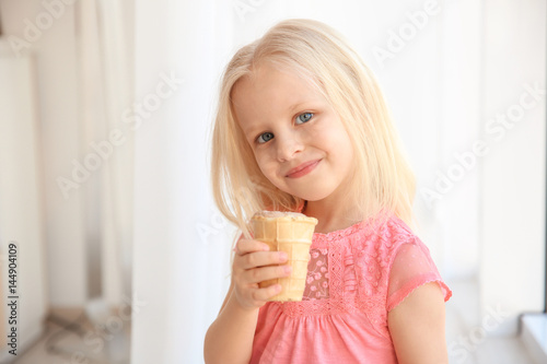 Cute little girl eating ice cream at home