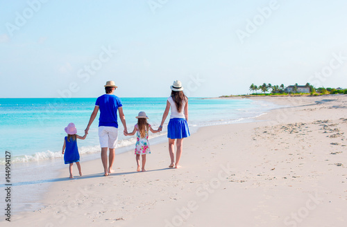 Happy beautiful family of four on a tropical beach vacation