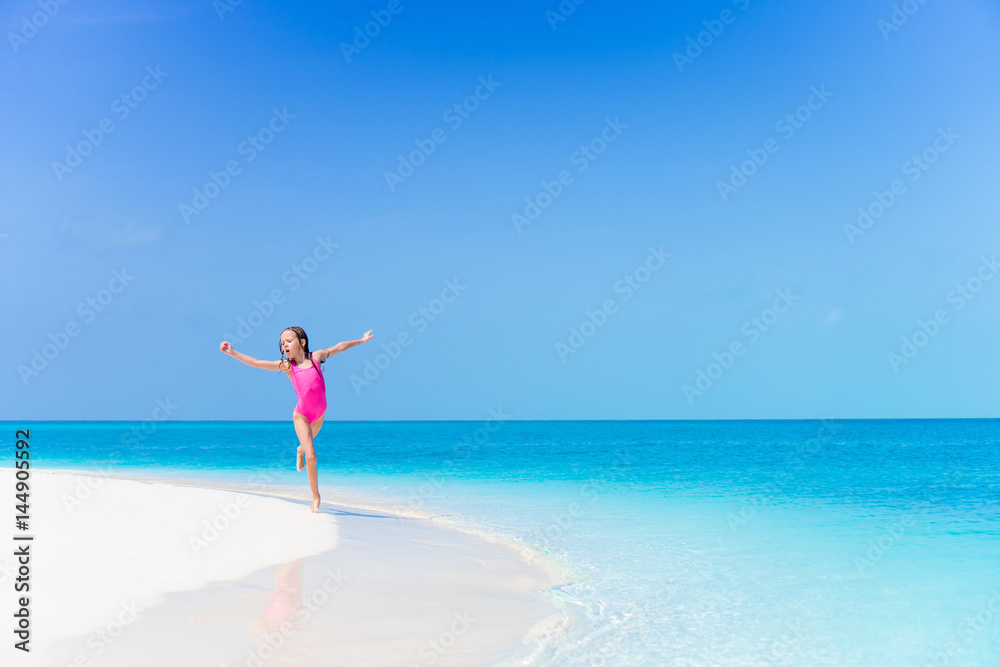 Little girl at beach having a lot of fun in shallow water on the beach Little girl at beach having a lot of fun in shallow water on the beach