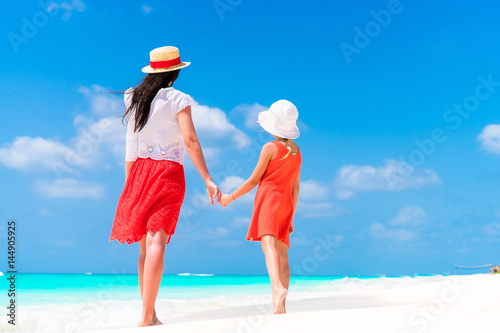 Fotografi Little adorable girl and young mother at tropical beach