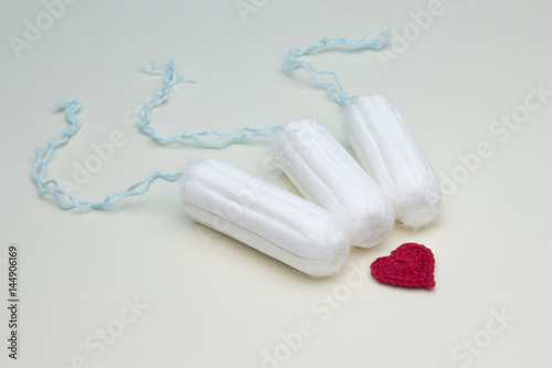 Three menstruation cotton tampons for woman hygiene protection  crochet heart. Soft tender protection for woman critical days  gynecological menstruation cycle. Medical hygiene conception