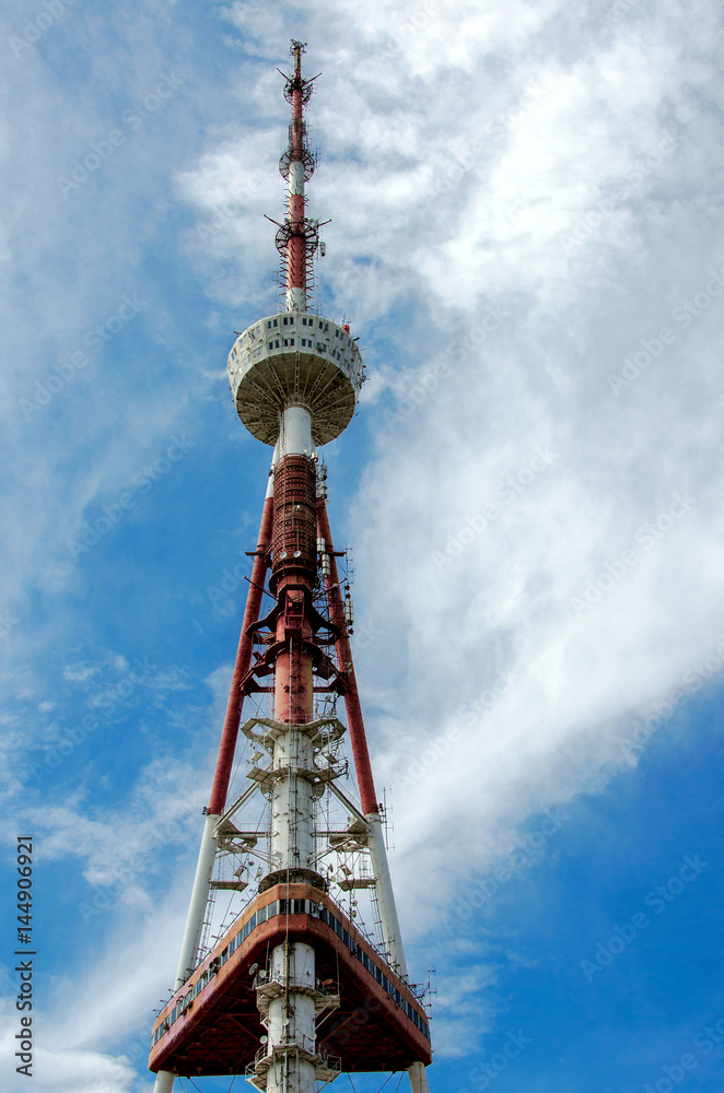 A television tower against the blue sky and clouds. A television tower against the blue sky and clouds.