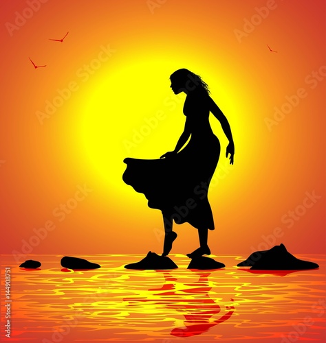 ragazza passeggia sugli scogli al mare al tramonto