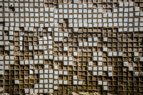 Old wall made of small ceramic tiles