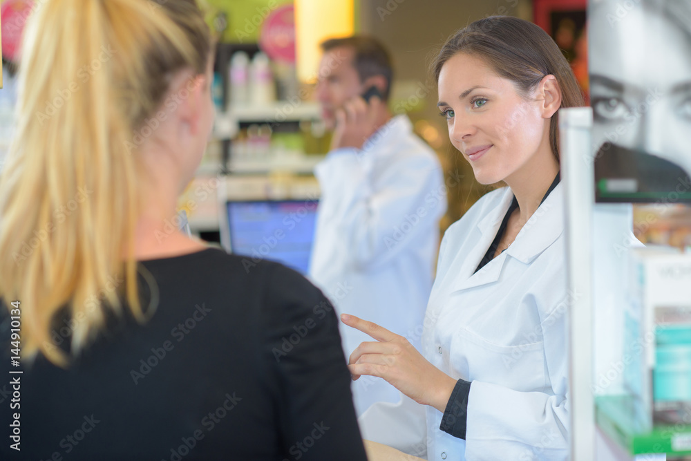 Pharmacist serving female customer Pharmacist serving female customer