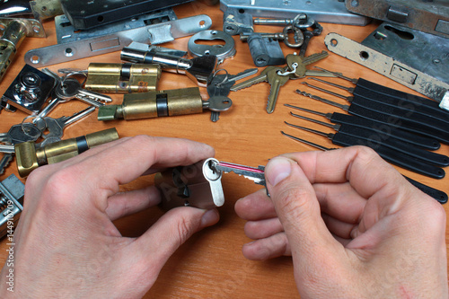 Locksmith inserts key in cylinder lock photo