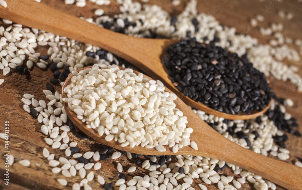 Fresh black and white sesame seeds in spoons Fresh black and white sesame seeds in spoons