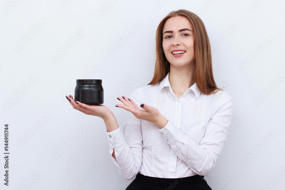 Young beautiful smiling woman with cosmetics bottle isolated on white background