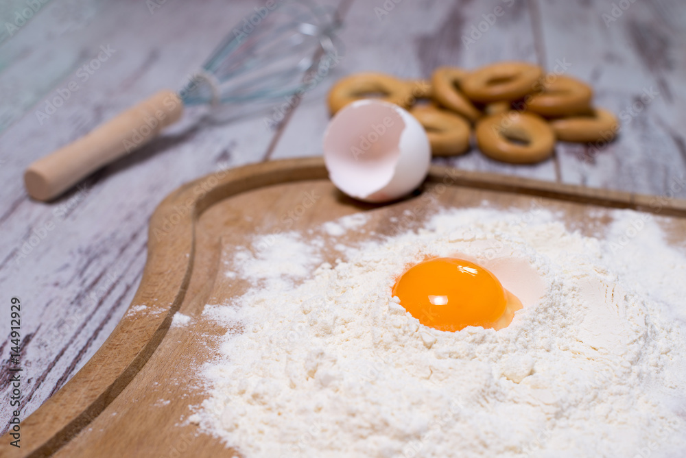 Baking concept. Sprinkled flour and eggs on wooden cutting board, cooking ingredients. Prepare for making yeast dough. Top view, copy space