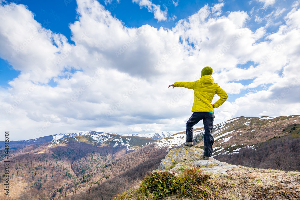 Obraz premium A woman is standing on the summit, beautiful sunny day.