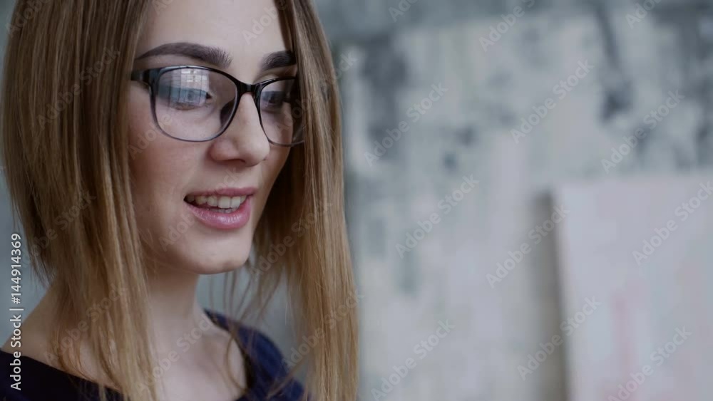 Close up smiling woman is holding brush and pallette of collors imagining what to paint Close up smiling woman is holding brush and pallette of collors imagining what to paint