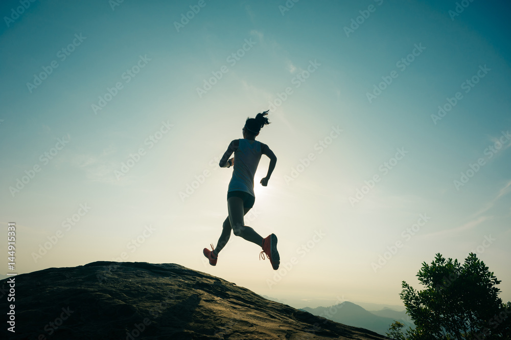 Young fitness woman trail runner running at mountain top Young fitness woman trail runner running at mountain top