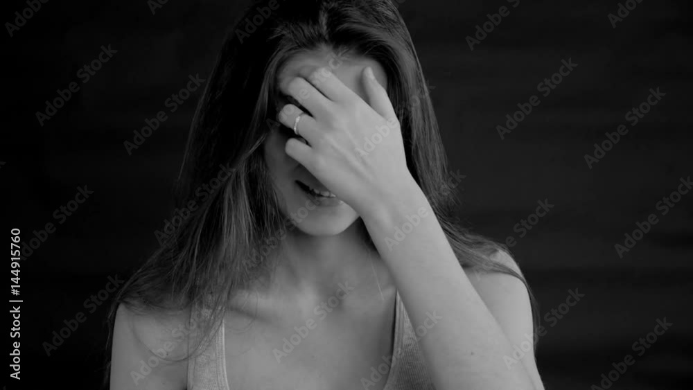Woman feeling lonely and sad crying slow motion black background