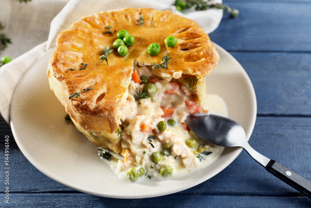 Tasty chicken pot pie with green peas on plate