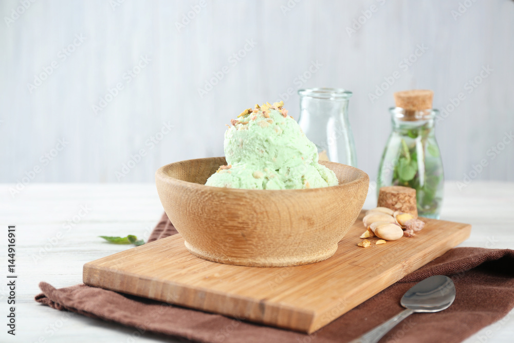 Bowl with delicious pistachio ice cream on wooden board Bowl with delicious pistachio ice cream on wooden board