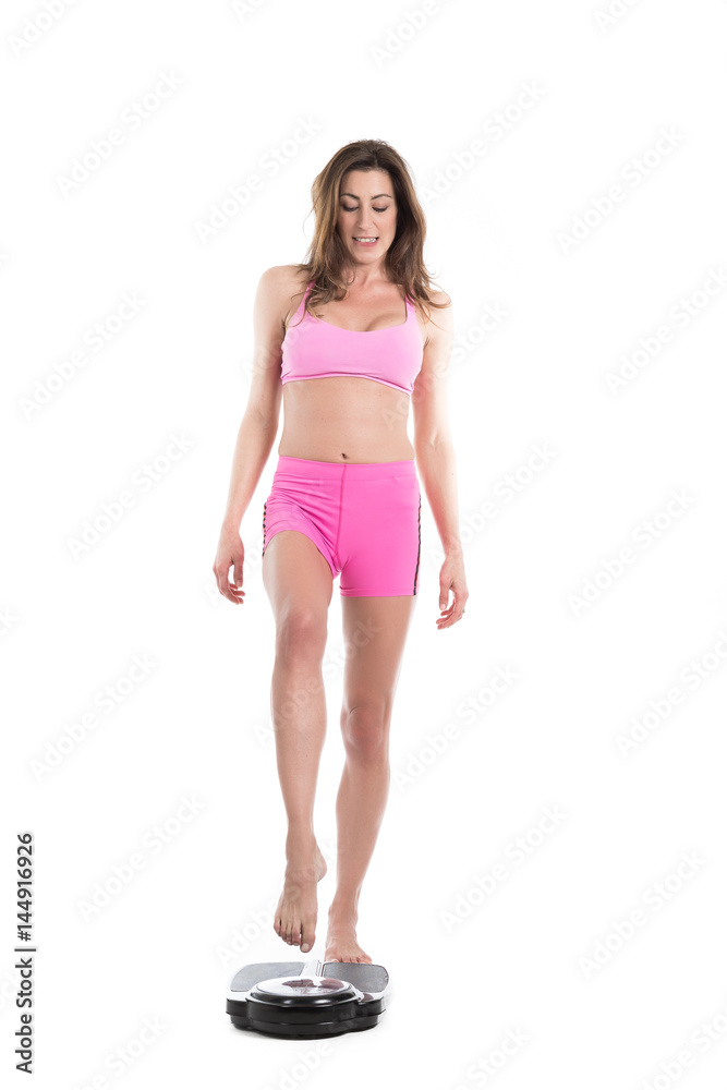 Young woman near scale unhappy with her weight gesturing sadness. Fit and healthy concept. Isolated over white background Young woman near scale unhappy with her weight gesturing sadness. Fit and healthy concept. Isolated over white background