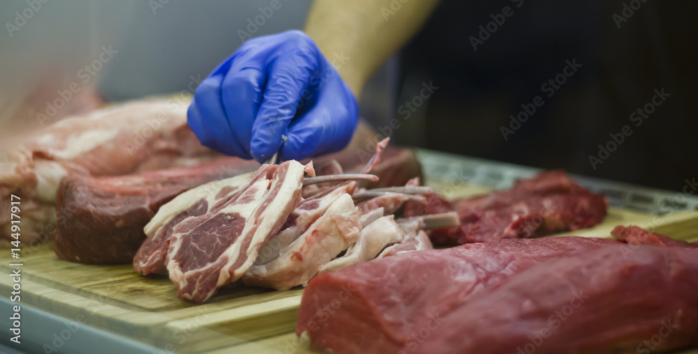 Taking a Lamb cutlet from a showcase