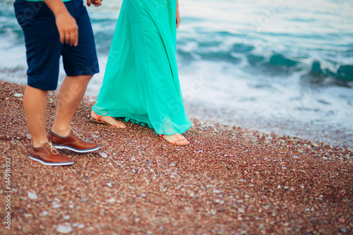 Women's and men's feet in the sand. Wedding in Montenegro