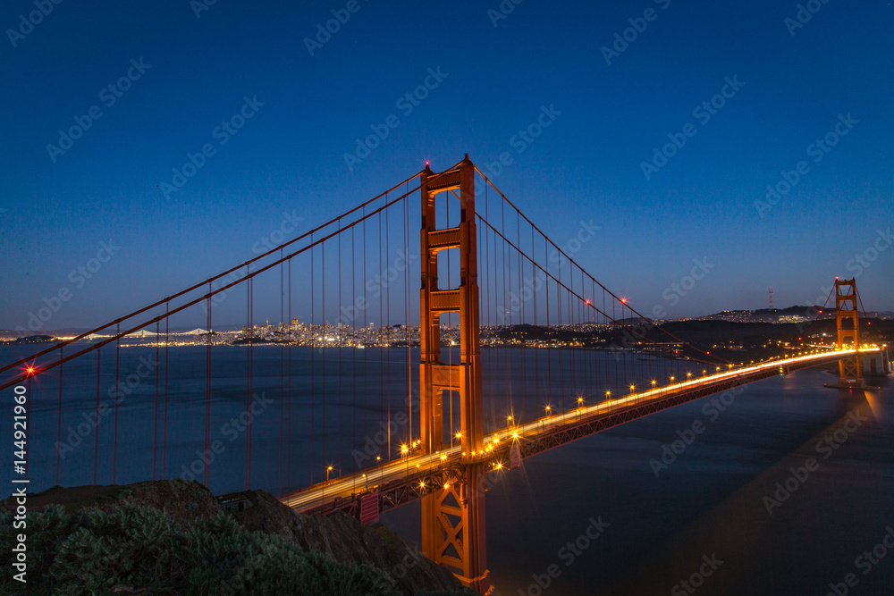 Aerial view of the Golden Gate bridge in San Fransisco during golden hour and traffic