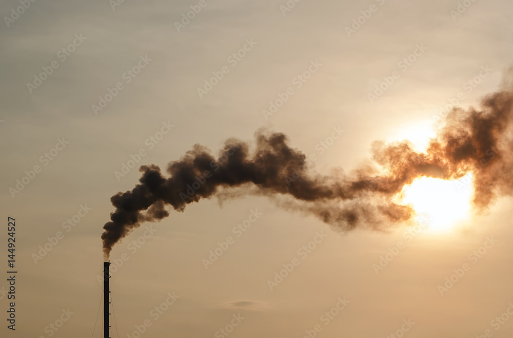Sunrise silhouette of  smoking factory