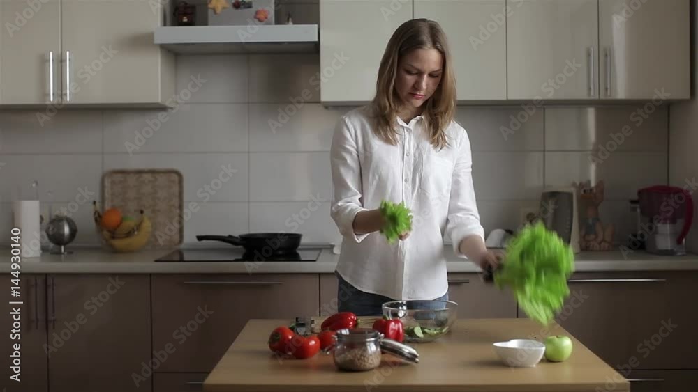 Business Woman Preparing Dinner in the Kitchen, Prepares a Vegetarian Salad. Tearing Salad Business Woman Preparing Dinner in the Kitchen, Prepares a Vegetarian Salad. Tearing Salad