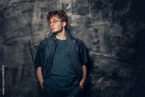 Young man in eyeglasses over grey background.