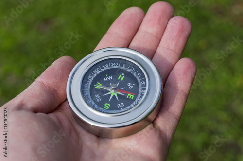 Hand holding compass in forest