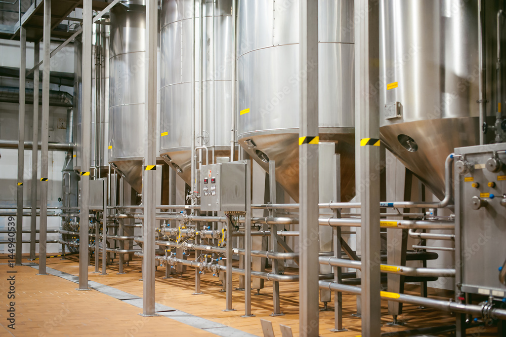 Beer manufacture line. Equipment for staged production bottling of Finished food products. Metal structures, pipes and tanks at enterprise factory. Special equipment inside within industrial premises