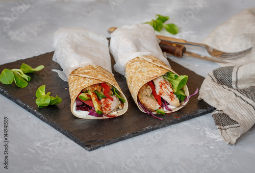 Homemade spicy tortilla wrap with a mix of ingredients: chicken, vegetables and ricotta.