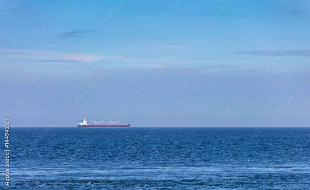 Large cargo tanker sailing across a blue sea horizon