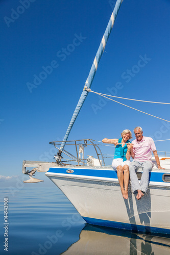Happy Senior Couple Sitting on the Side of a Sail Boat © spotmatikphoto