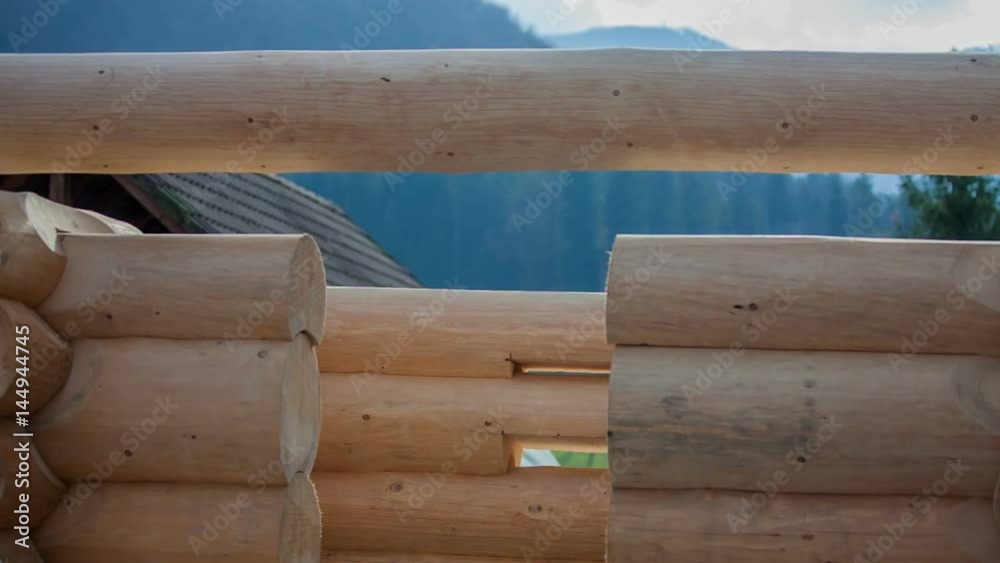 People are building a wooden construction. It is a nice summer day and they are in the middle of construction.
