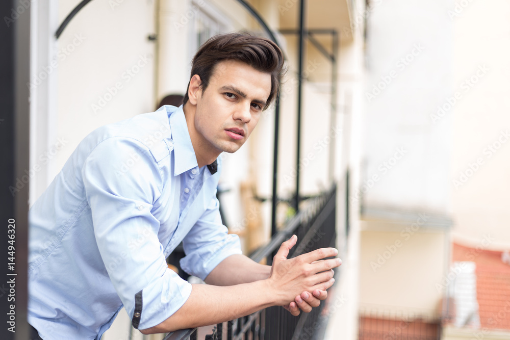 Young serious man in blue shirt posing Young serious man in blue shirt posing