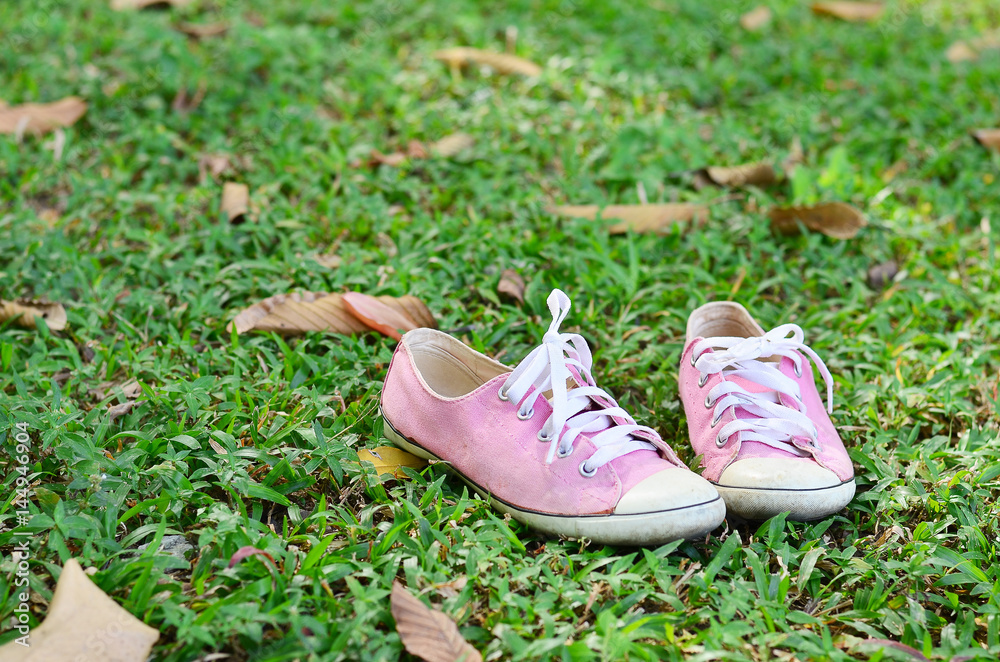 Pink sneakers put on grass
