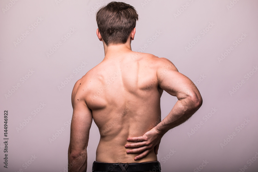 Fototapeta premium Man rubbing his painful back on grey . Pain relief, chiropractic concept