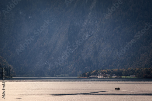Boat and unidentified people at pier at St. Bartholoma church at lake nearby Schonau am Konigssee in Germany. photo