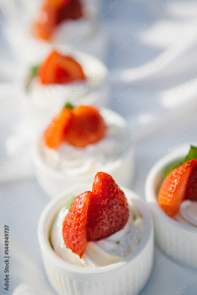 Cupcakes with whipped cream decorated with fresh strawberries Cupcakes with whipped cream decorated with fresh strawberries