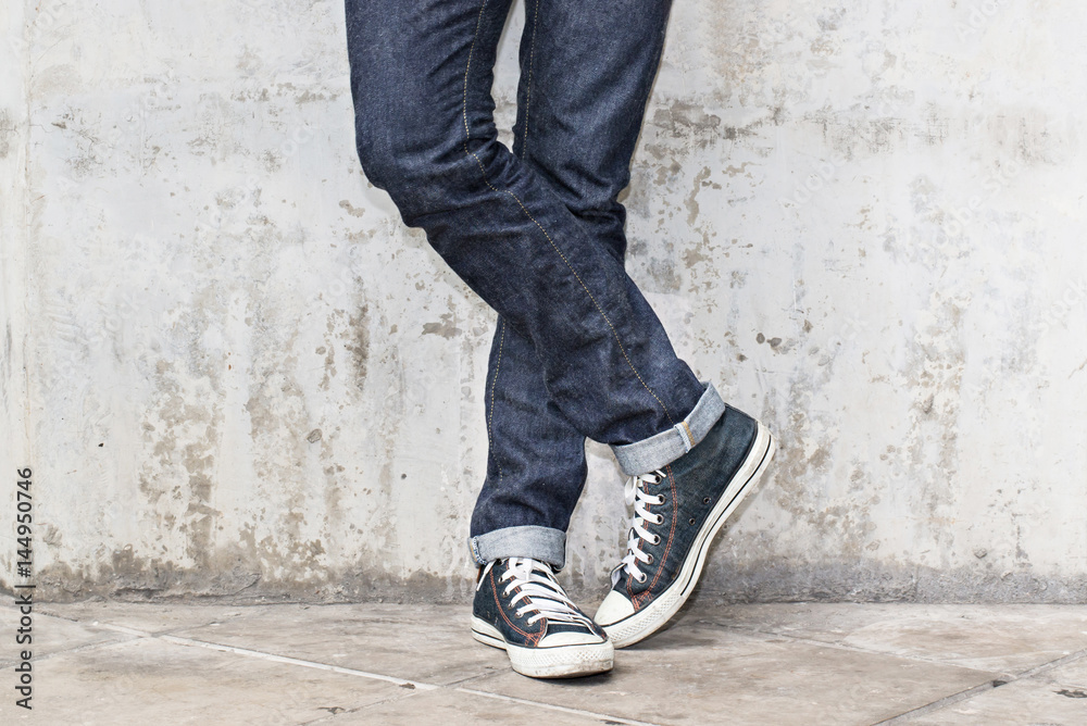 Regular Fit Straight Leg Jeans and Retro Canvas High Top Sneakers on  Plaster wall background, selective focus (detailed close-up shot) Stock  Photo | Adobe Stock