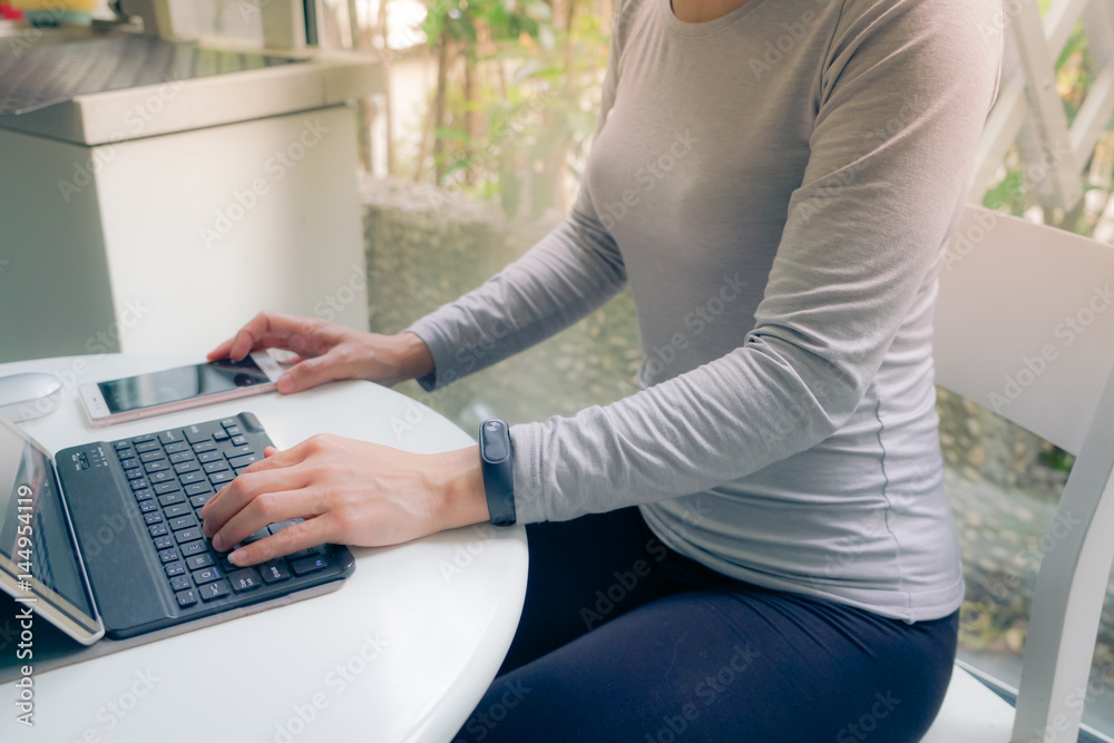 Naklejka premium Young student women wearing smart band using tablet computer