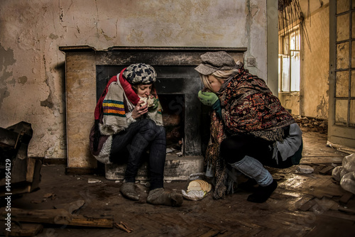 Two drifters eating bread at abandoned house photo