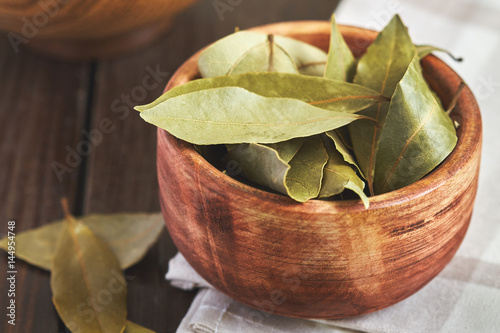Fotografie, Tablou Dry bay leaves (Laurus nobilis) in wooden bowl
