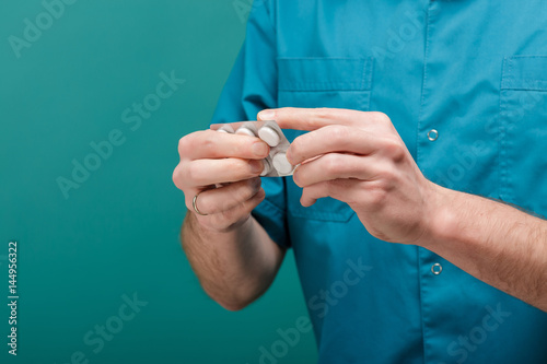 close-up of male doctor's hand give white tablets. blisters of pills