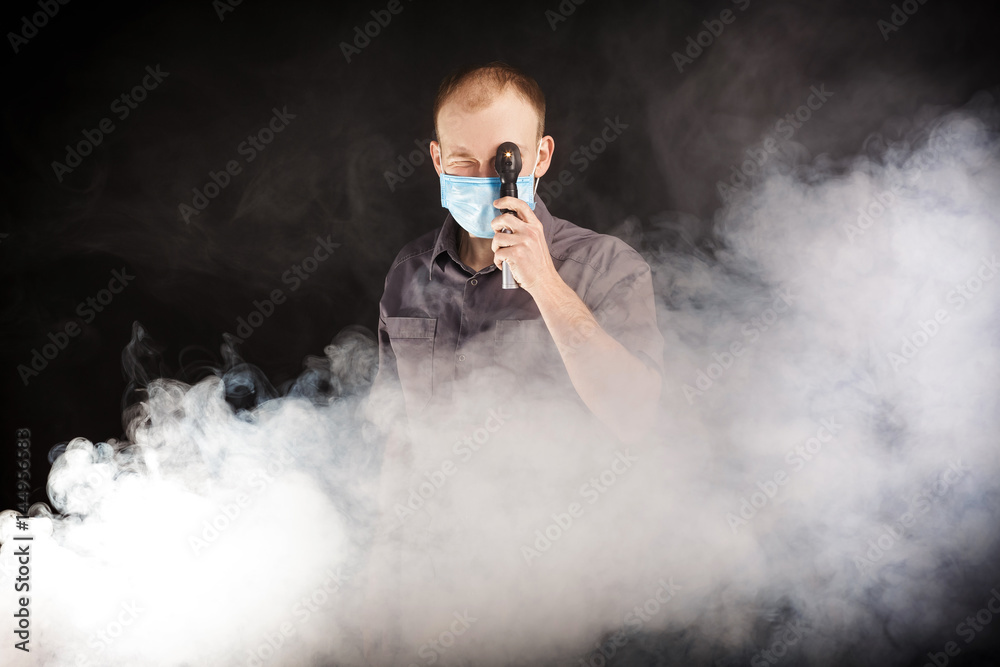 young doctor in a mask in smoke young doctor in a mask in smoke