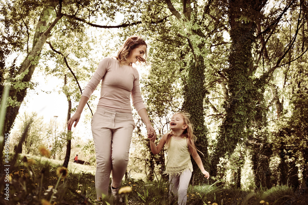 Mother and daughter walking in meadow. Mother and daughter walking in meadow.