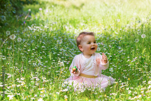 Beautiful baby girl among spring flowers