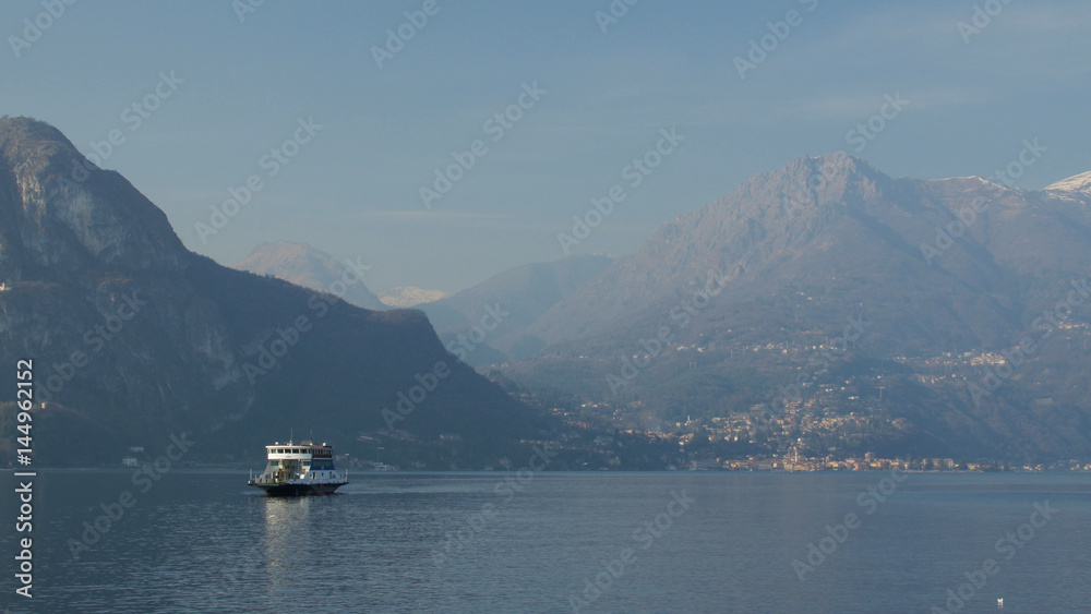 Ferry sailing through a mountain lake. Lake Como, Italy. February