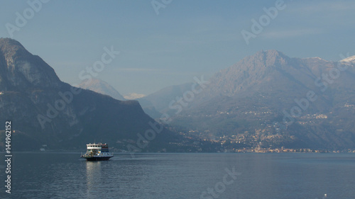 Ferry sailing through a mountain lake. Lake Como, Italy. February