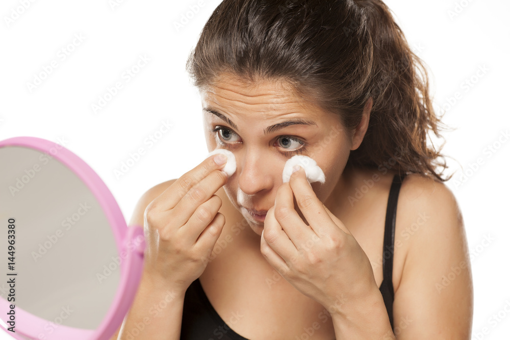 young woman cleans her face using tonic and cotton pads young woman cleans her face using tonic and cotton pads