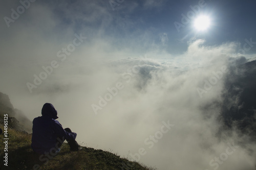 Man on the peak of mountains at sunrise - meditation