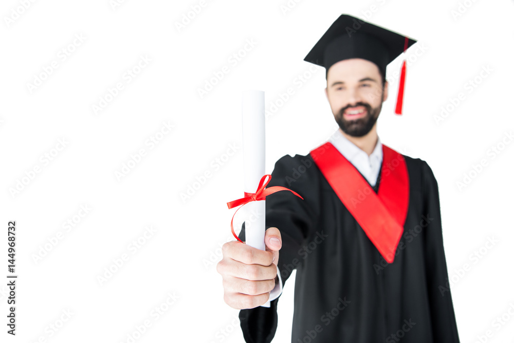 Smiling young man in graduation gown holding certificate Smiling young man in graduation gown holding certificate
